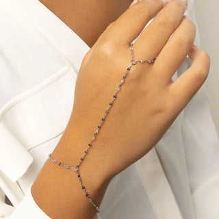 Hand wearing a delicate silver Lip Hand Chain on a white background