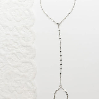 Silver beaded Lip Hand Chain on a textured white background
