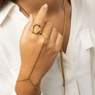 Gold ring and Singapore Hand Chain set on a hand with a white background