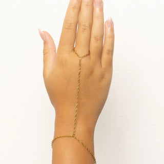 Hand wearing a gold Singapore Hand Chain on a white background