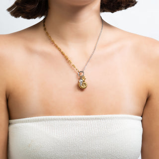 Necklace with a pendant on a person wearing a white top against a light background
