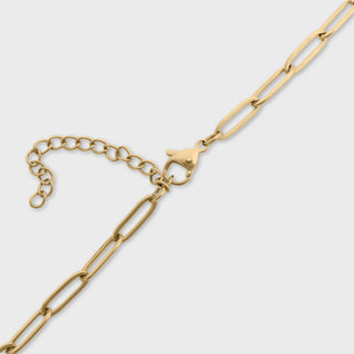 Gold chain necklace on a light gray background