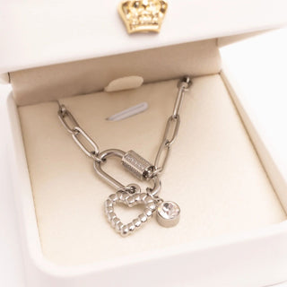 Silver bracelet with heart-shaped charm in a box
