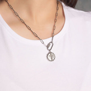 Silver chain necklace with a pendant worn by a person on a white background