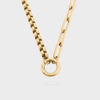 Gold chain necklace with a unique clasp on a light gray background