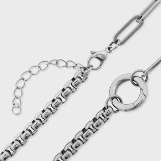 Silver chain necklace on a light gray background