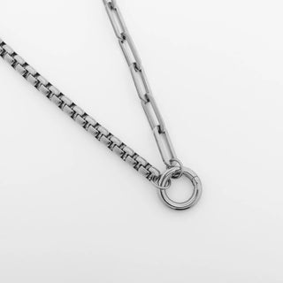 Silver chain necklace on a light gray background
