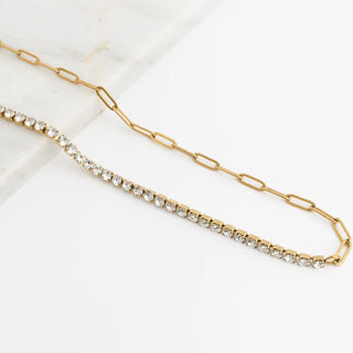 Gold chain necklace with embedded crystals on a white background