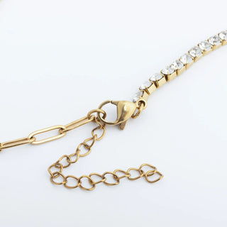 Gold bracelet with heart-shaped clasp on a white background