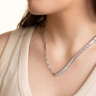 Silver necklace on a person against a neutral background