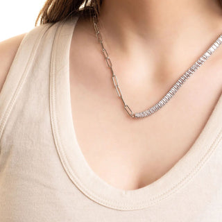 Silver necklace on a person wearing a beige tank top against a neutral background