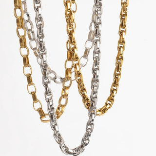 Three chain necklaces in gold and silver on a white background