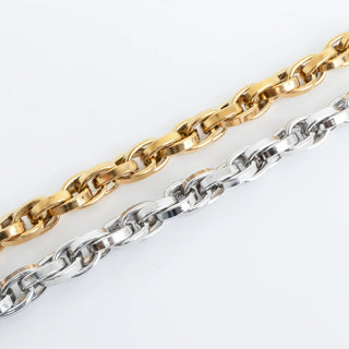 Gold and silver chain bracelets on a light gray background