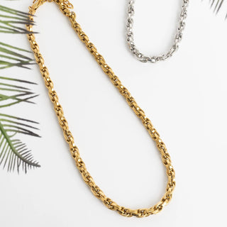 Gold chain necklace on a white background with a silver chain in the background