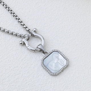 Silver necklace with a pendant on a light gray background