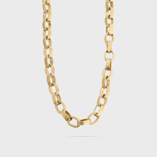 Gold chain necklace on a light gray background