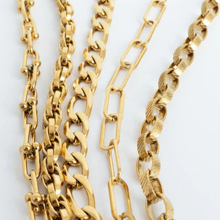 Three gold chains of different designs on a white background