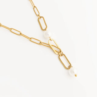 Gold chain necklace with a pearl on a white background