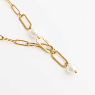 Gold chain necklace with pearls on a white background