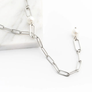 Silver y-shaped chain necklace with pearl-like beads on a white background