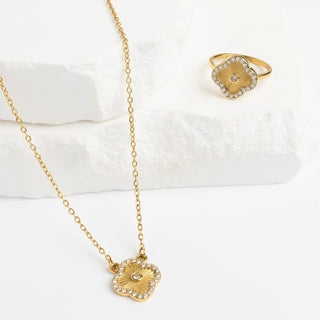Gold necklace and ring on a white surface