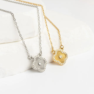 Two necklaces with floral-shaped pendants on a white background
