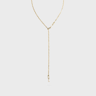 Gold lariat necklace on a light gray background