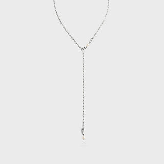 Silver lariat necklace on a light gray background