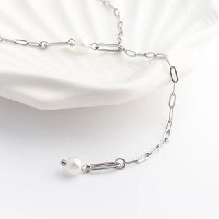 Silver chain necklace with pearls on a white background