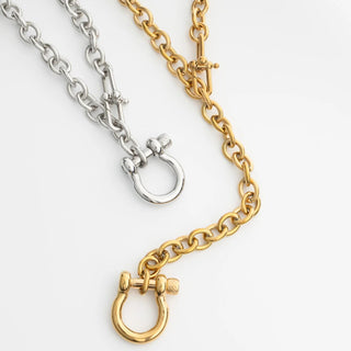 Two chain necklaces, one silver and one gold, on a white background.