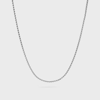 Silver chain necklace on a light gray background