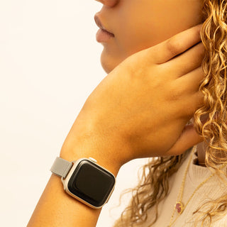 Person wearing a smartwatch with a neutral background