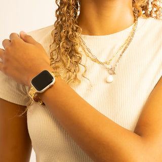 Person wearing a gold smartwatch on a plain background