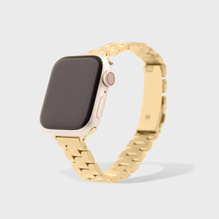 Smartwatch with a gold metal band on a light gray background
