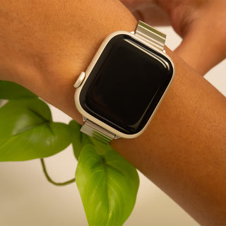 Smartwatch on a wrist with a plant in the background