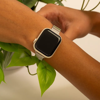 Person wearing a smartwatch with a plant in the background