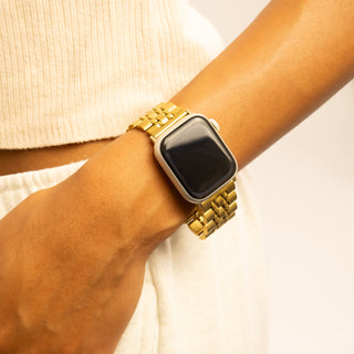 Gold smartwatch on a wrist with a neutral background