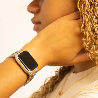 Person wearing a smartwatch with a neutral background