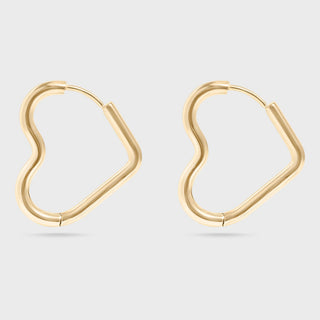 Heart Shaped gold hoop earrings on a light gray background