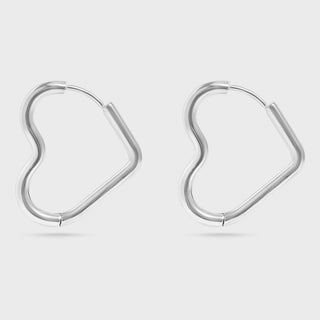 Pair of heart shaped silver hoop earrings on a light gray background