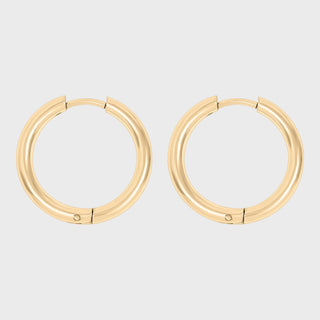 Gold hoop earrings on a light gray background