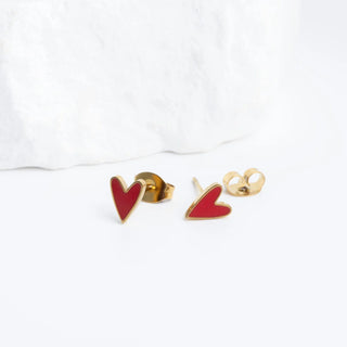 Red heart-shaped earrings with gold posts on a white background