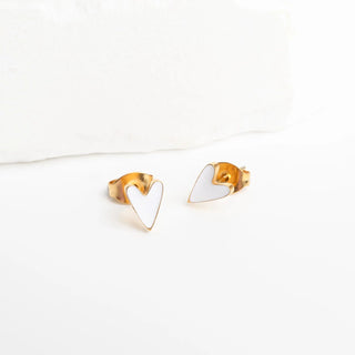 Heart-shaped gold and white earrings on a white background