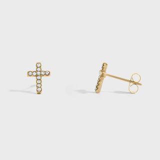 Gold cross-shaped earrings on a light gray background