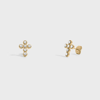 Gold cross-shaped earrings with small stones on a light gray background