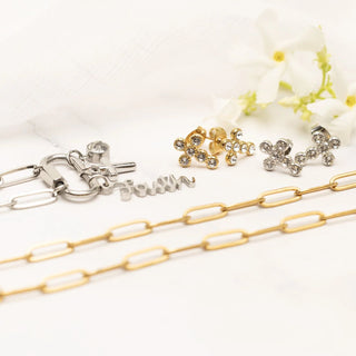 Gold and silver chain necklaces with pendants and earrings on a white background