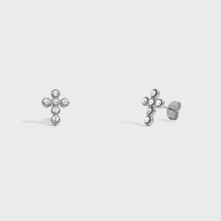 Silver cross-shaped earrings on a light gray background