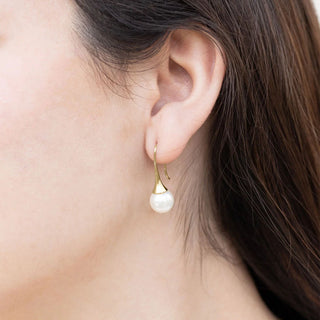 Pearl earring worn by a person with a blurred background