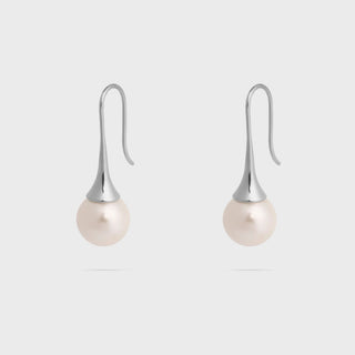 Pearl earrings with silver hooks on a light gray background