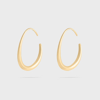 Gold hoop earrings on a light gray background